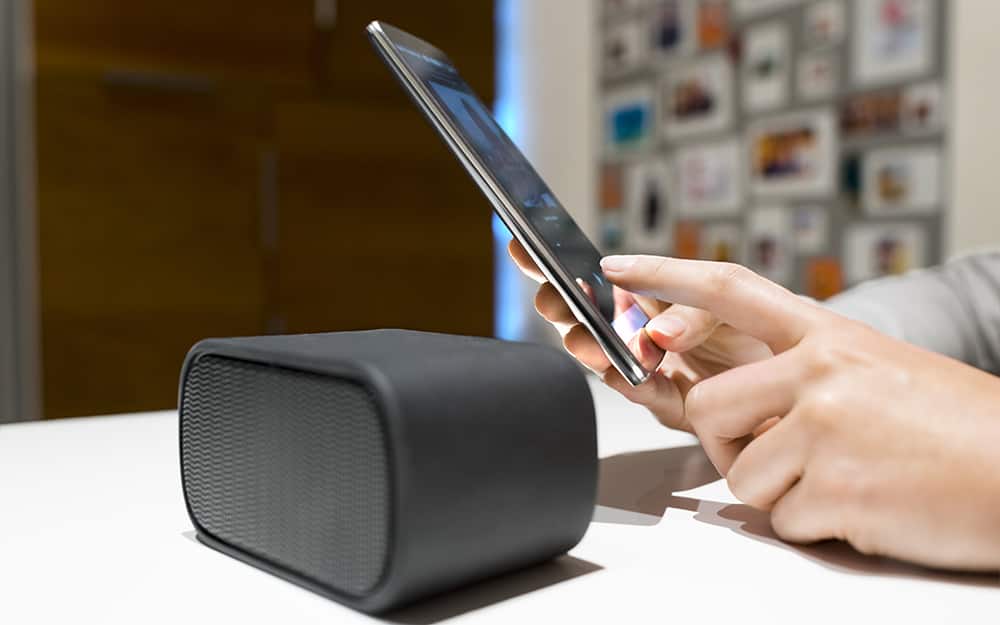 A person programming a smart home device with a smart phone.