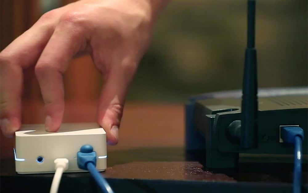A person connecting a smart home device to a router.